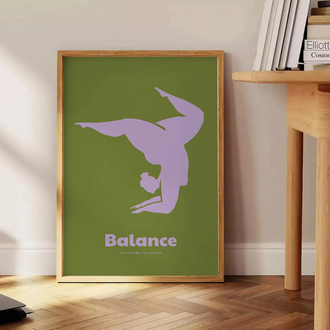 Poster showing minimalist yoga balance silhouette in green and blue watercolor - beside a round wooden side table with books