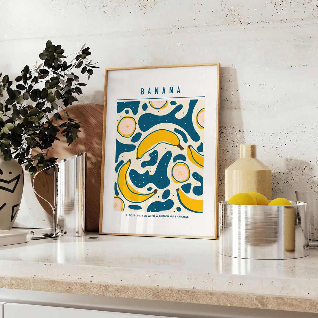 Gray and orange minimalist banana kitchen art poster, modern playful design - styled on a counter with eucalyptus and a bowl of lemons