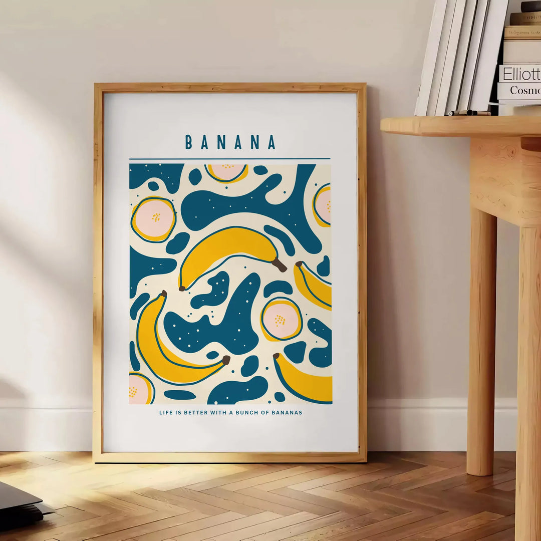Gray and orange minimalist banana kitchen art poster, modern playful design - beside a round wooden side table with books