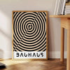 Bauhaus-Plakat mit minimalistischer, geometrischer abstrakter Komposition und klarer Gestaltung - neben einem runden Beistelltisch aus Holz mit Büchern