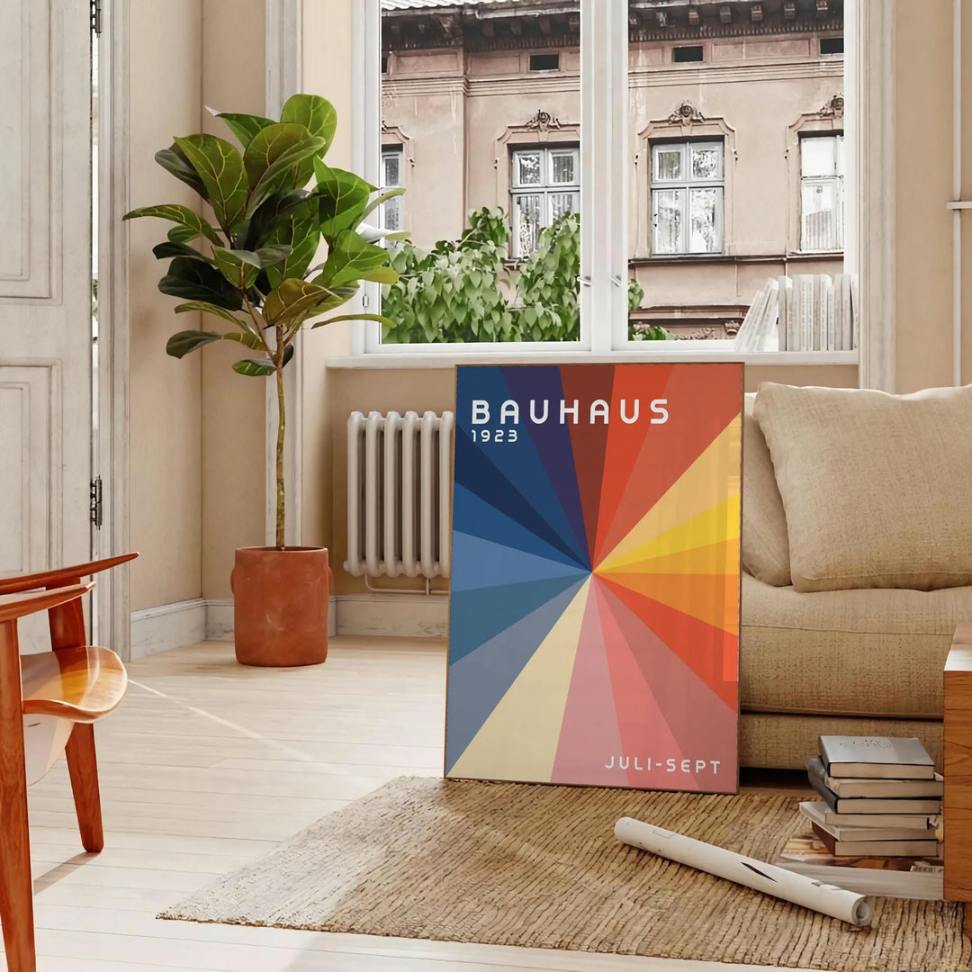 Bauhaus geometric artwork poster with bold primary colors and shapes - in a Parisian living room with a sofa and a fig plant