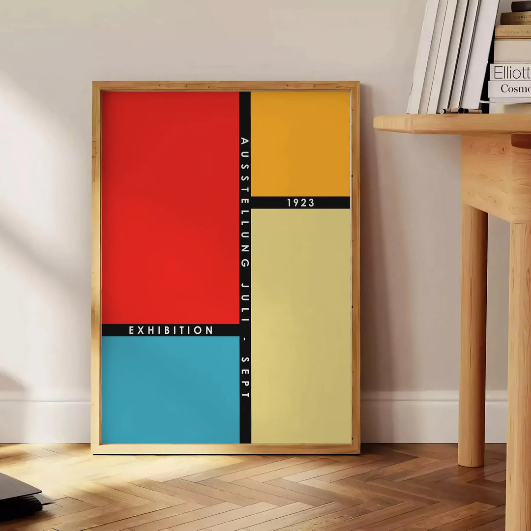 Bauhaus geometric art poster showing abstract shapes and minimal composition - beside a round wooden side table with books