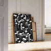 Black and gray Bauhaus poster with geometric modern abstract design - leaning on a herringbone floor against a white panelled wall