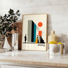 Bauhaus poster of stylized human figure in orange and white - styled on a counter with eucalyptus and a bowl of lemons