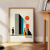 Bauhaus poster of stylized human figure in orange and white - beside a round wooden side table with books