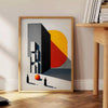 Bauhaus poster featuring a stylized human figure in orange and black - beside a round wooden side table with books