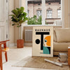 Pôster com figura humana em estilo Bauhaus e formas geométricas minimalistas - numa sala parisiense com sofá e um ficus