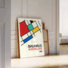 Bauhaus poster showing abstract geometric composition with modern minimalist design - leaning on a herringbone floor against a white panelled wall