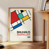 Bauhaus poster showing abstract geometric composition with modern minimalist design - beside a round wooden side table with books