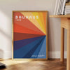Bauhaus poster showing abstract geometric composition in minimalist modern style - beside a round wooden side table with books