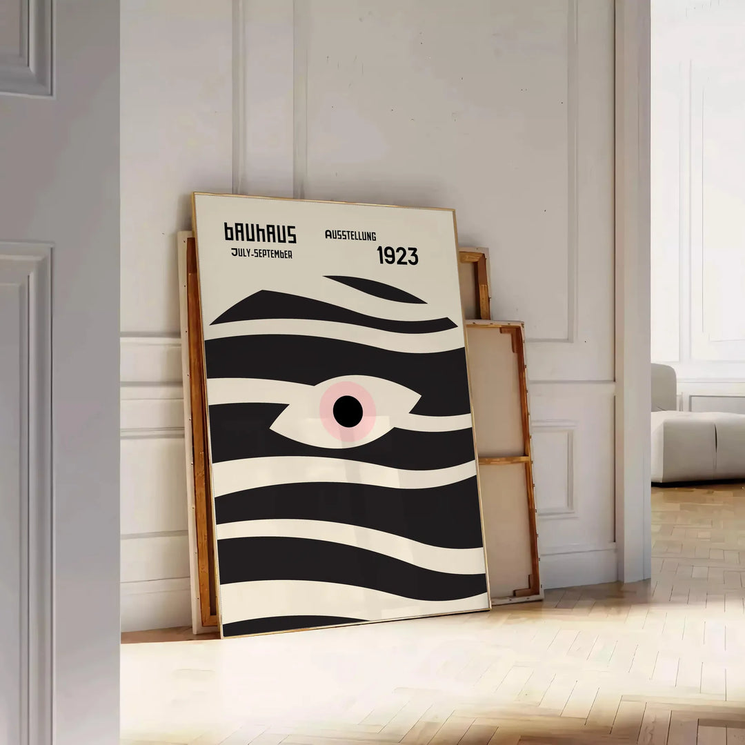 Poster showing geometric abstract Bauhaus composition with bold shapes - leaning on a herringbone floor against a white panelled wall