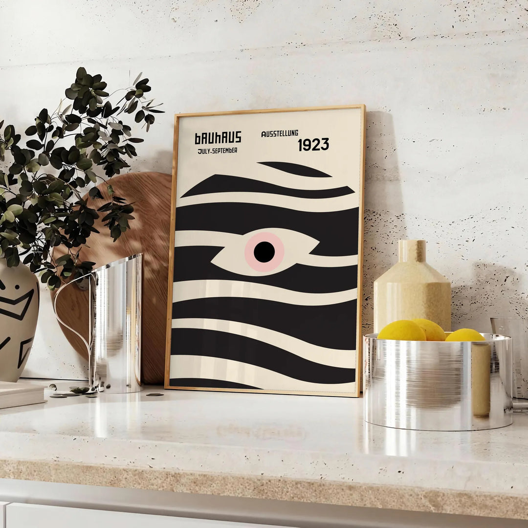 Poster showing geometric abstract Bauhaus composition with bold shapes - styled on a counter with eucalyptus and a bowl of lemons