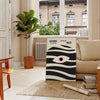 Poster showing geometric abstract Bauhaus composition with bold shapes - in a Parisian living room with a sofa and a fig plant