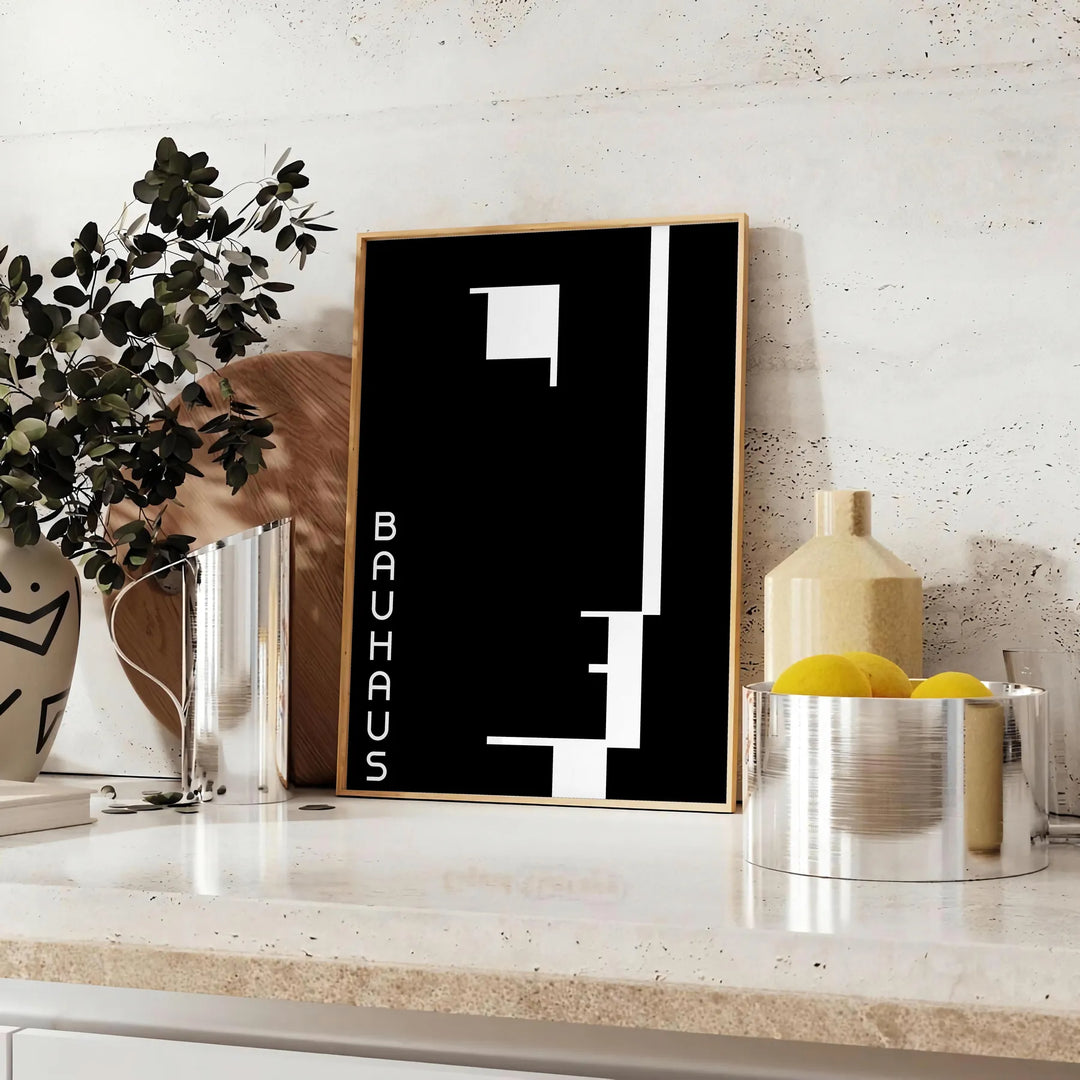Composição geométrica em preto e cinza inspirada no design Bauhaus - sobre uma bancada com eucalipto e uma taça de limões