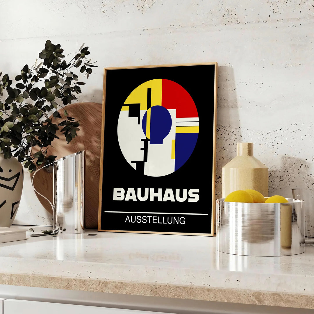 Bauhaus Poster mit geometrischen abstrakten Formen in kräftigen Primärfarben - auf einer Arbeitsplatte mit Eukalyptus und einer Schale Zitronen
