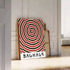 Poster con composizione geometrica astratta Bauhaus in stile minimalista - appoggiato su un pavimento a spina di pesce contro una parete a pannelli