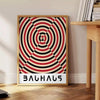 Poster con composizione geometrica astratta Bauhaus in stile minimalista - accanto a un tavolino rotondo in legno con libri