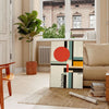 Bauhaus-Poster mit geometrischem Design in Orange und Schwarz - in einem Pariser Wohnzimmer mit Sofa und einer Geigenfeige