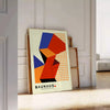 Cartel Bauhaus con diseño geométrico abstracto en rojo y naranja - apoyado en un suelo de espiga contra una pared de molduras