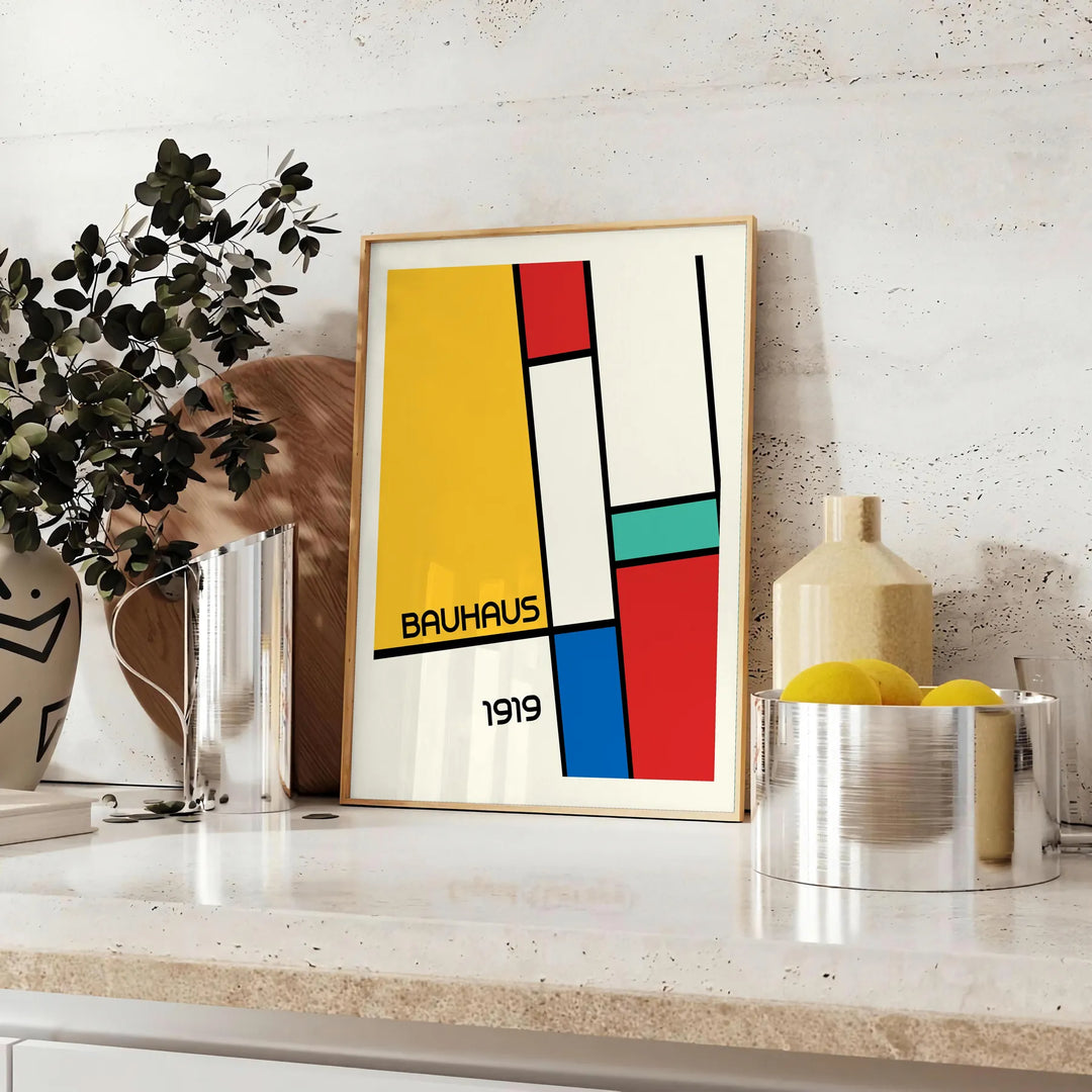 Gedrucktes Poster mit Bauhaus-geometrischer abstrakter Komposition im minimalistischen Stil - auf einer Arbeitsplatte mit Eukalyptus und einer Schale Zitronen