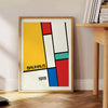 Gedrucktes Poster mit Bauhaus-geometrischer abstrakter Komposition im minimalistischen Stil - neben einem runden Beistelltisch aus Holz mit Büchern