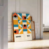 Bauhaus-style abstract geometric poster in orange and blue - leaning on a herringbone floor against a white panelled wall