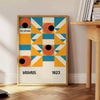 Bauhaus-style abstract geometric poster in orange and blue - beside a round wooden side table with books