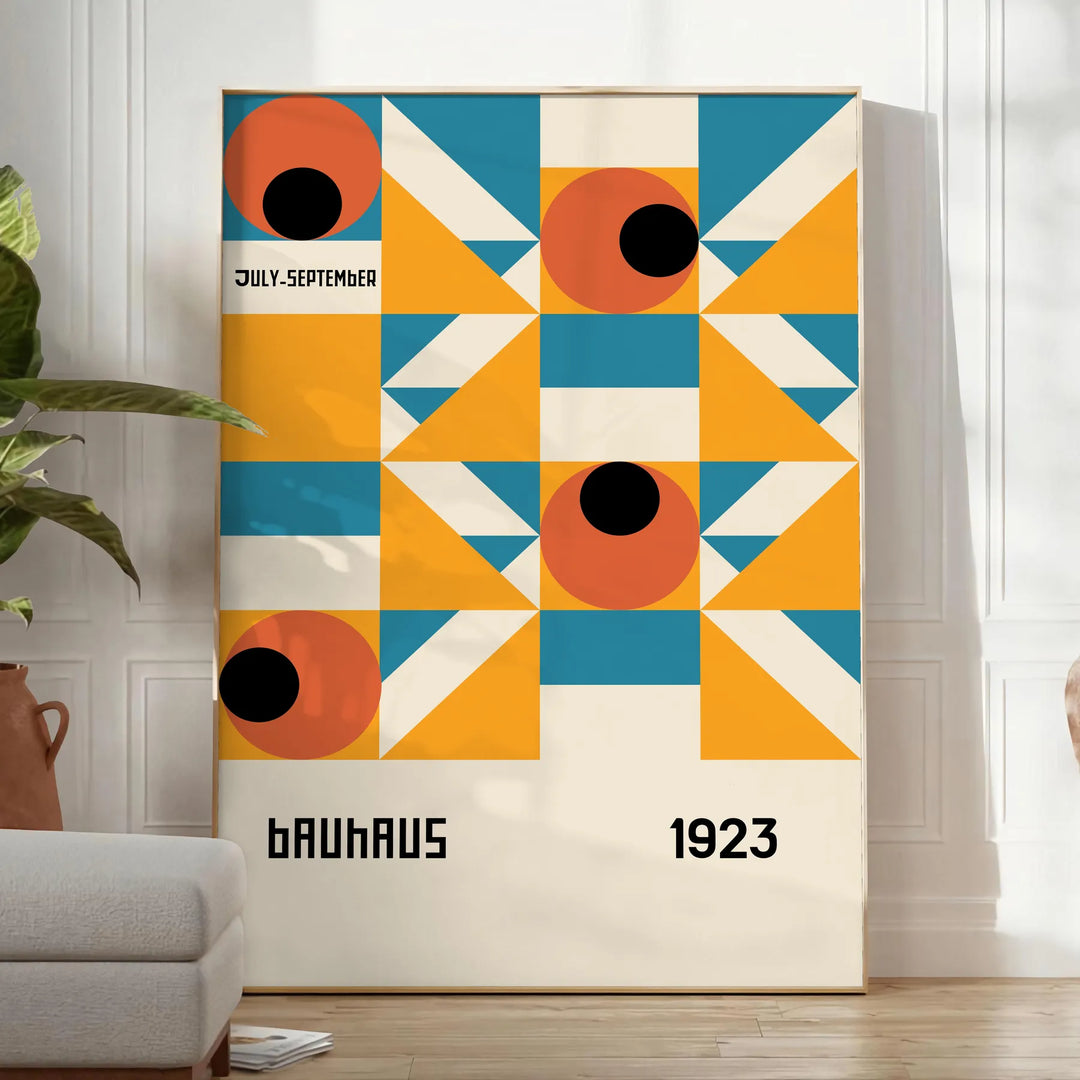 Bauhaus-style abstract geometric poster in orange and blue - in a bright minimalist room with a plant and an armchair
