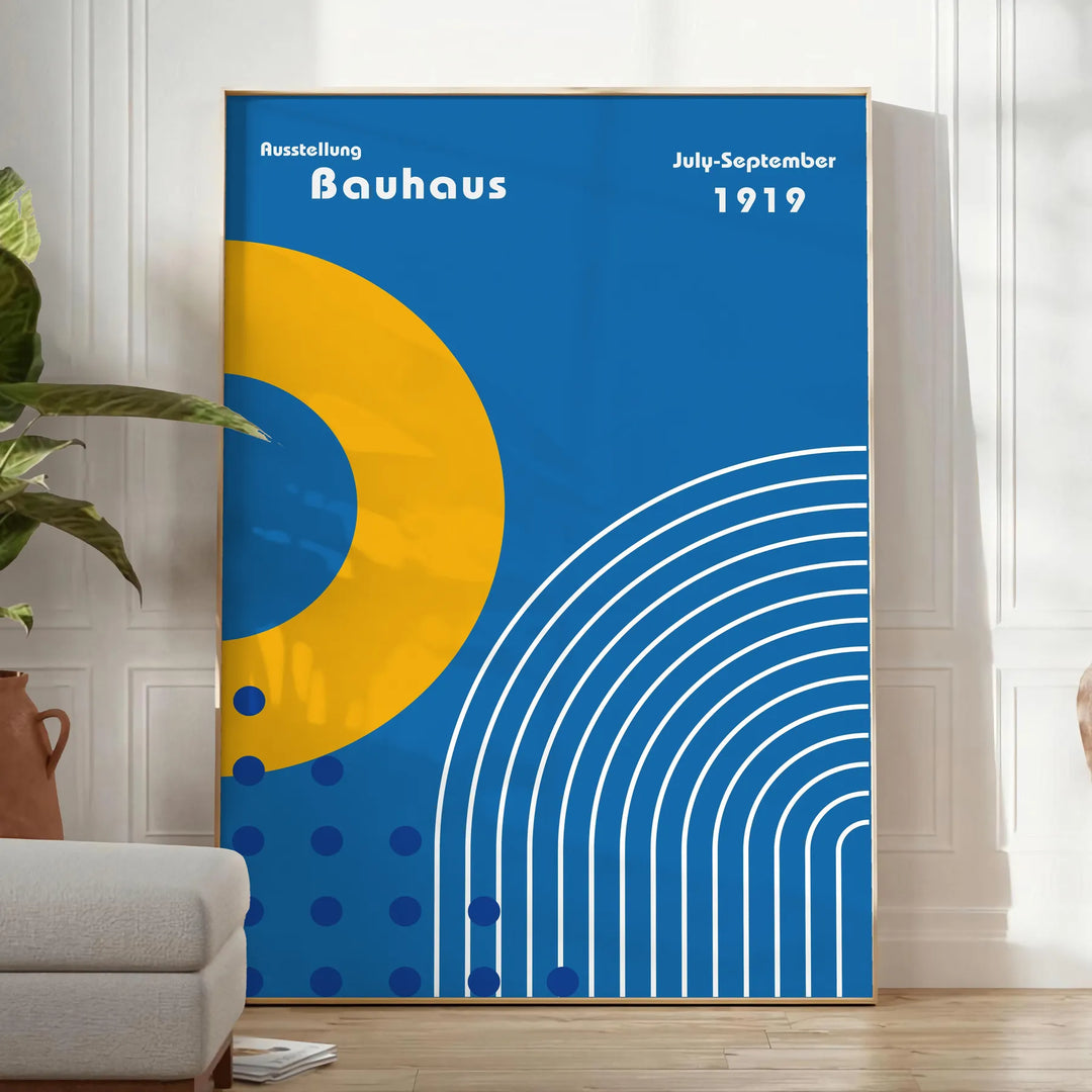 Minimalistyczny plakat Bauhaus z szarymi i żółtymi kształtami geometrycznymi - w jasnym minimalistycznym pokoju z rośliną i fotelem