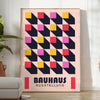 Schwarz-gelbes Bauhaus Plakat mit geometrischem abstraktem Design und kräftigen Formen - in einem hellen minimalistischen Raum mit Pflanze und Sessel