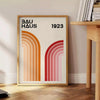 Bauhaus poster showing abstract geometric forms and minimalist composition on paper - beside a round wooden side table with books