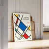 White and red geometric Bauhaus poster with bold minimalist abstract composition - leaning on a herringbone floor against a white panelled wall