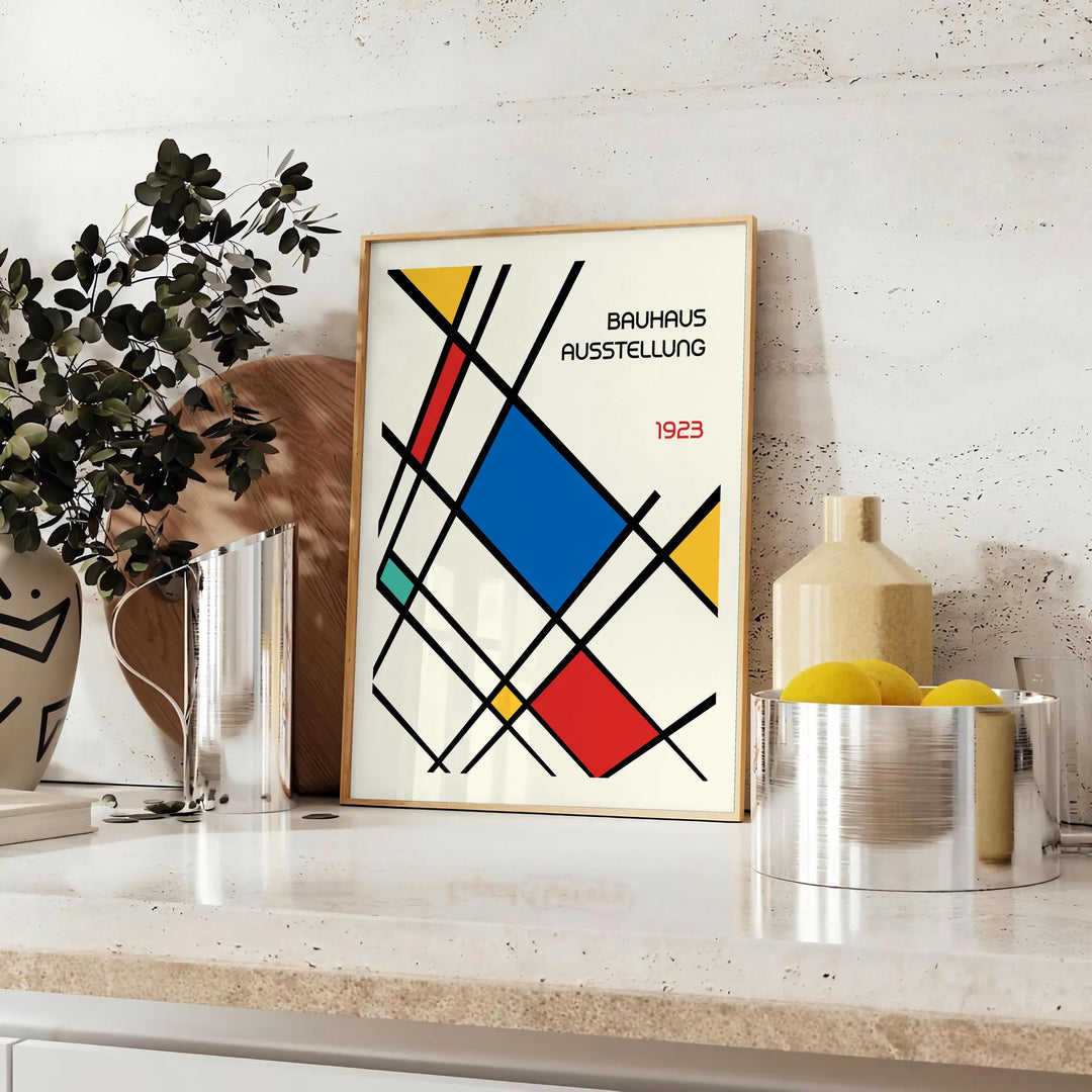 White and red geometric Bauhaus poster with bold minimalist abstract composition - styled on a counter with eucalyptus and a bowl of lemons
