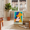 Bauhaus poster with geometric orange and green abstract shapes, modern style - in a Parisian living room with a sofa and a fig plant