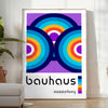 Poster mit abstraktem Bauhaus geometrischem Design in Primärfarben - in einem hellen minimalistischen Raum mit Pflanze und Sessel