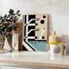 Bauhaus style illustration of a swimming pool with geometric shapes and muted colors - styled on a counter with eucalyptus and a bowl of lemons