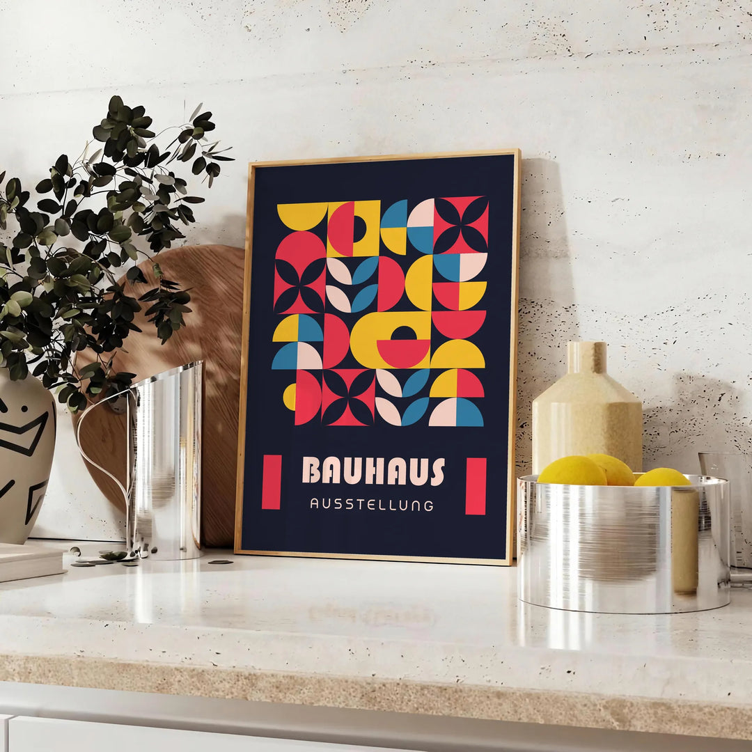 Plakat Bauhaus w odcieniach szarości i czerni, abstrakcyjna geometryczna kompozycja - na blacie z eukaliptusem i miską cytryn