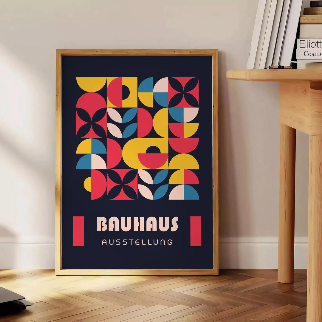 Plakat Bauhaus w odcieniach szarości i czerni, abstrakcyjna geometryczna kompozycja - obok okrągłego drewnianego stolika z książkami