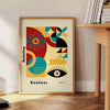 Formas geométricas minimalistas en estilo Bauhaus con colores primarios - junto a una mesa auxiliar redonda de madera con libros