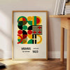 Poster Bauhaus con composizione geometrica astratta in verde e rosso intensi - accanto a un tavolino rotondo in legno con libri
