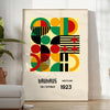 Poster Bauhaus con composizione geometrica astratta in verde e rosso intensi - in una stanza luminosa e minimalista con pianta e poltrona