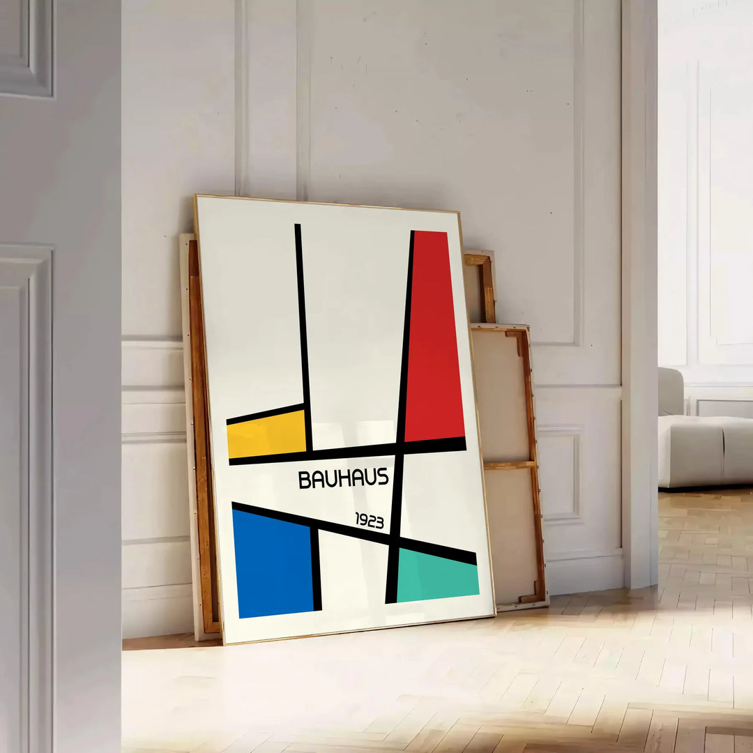 Bauhaus geometric poster with abstract shapes in red, blue, and yellow - leaning on a herringbone floor against a white panelled wall