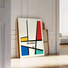 Bauhaus geometric poster with abstract shapes in red, blue, and yellow - leaning on a herringbone floor against a white panelled wall