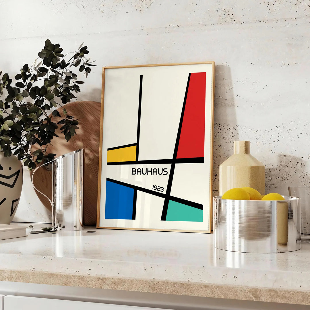 Bauhaus geometric poster with abstract shapes in red, blue, and yellow - styled on a counter with eucalyptus and a bowl of lemons