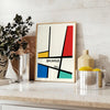 Bauhaus geometric poster with abstract shapes in red, blue, and yellow - styled on a counter with eucalyptus and a bowl of lemons