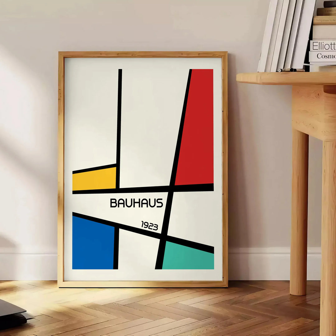 Bauhaus geometric poster with abstract shapes in red, blue, and yellow - beside a round wooden side table with books