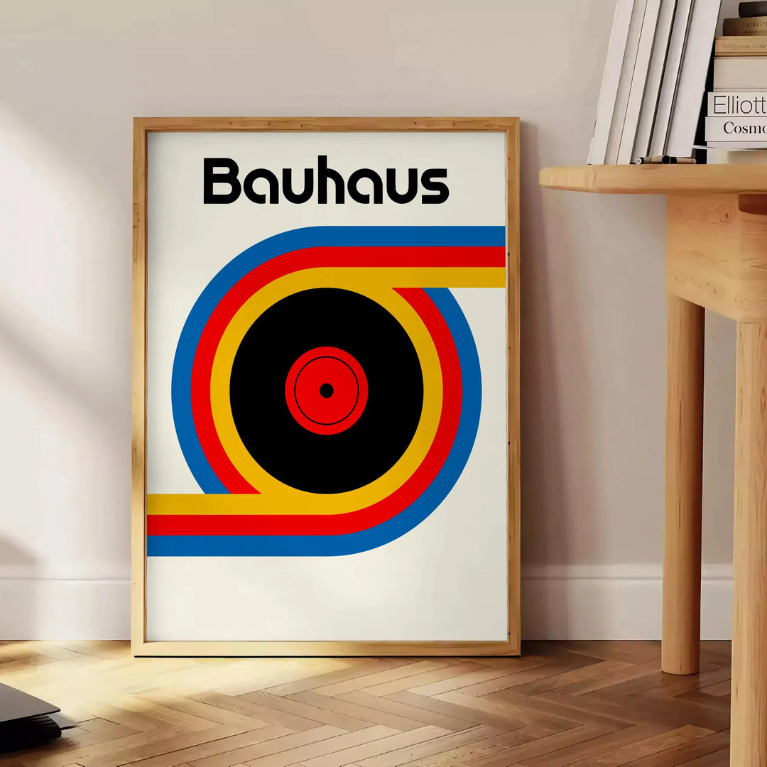 Poster showing Bauhaus geometric artwork with bold shapes and modern composition - beside a round wooden side table with books