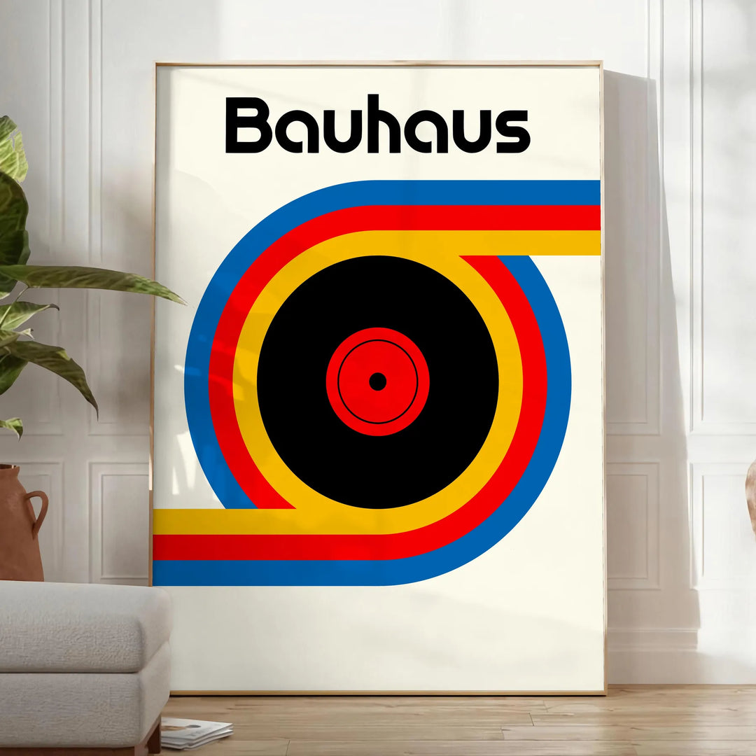 Poster showing Bauhaus geometric artwork with bold shapes and modern composition - in a bright minimalist room with a plant and an armchair