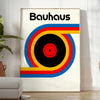 Poster showing Bauhaus geometric artwork with bold shapes and modern composition - in a bright minimalist room with a plant and an armchair