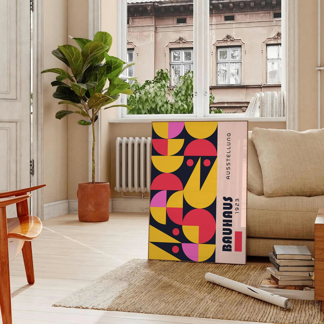 Poster showing abstract Bauhaus geometric artwork in yellow and black - in a Parisian living room with a sofa and a fig plant